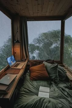 there is a bed in the room with a laptop on it and a window to the outside