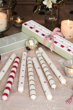 some candles are sitting on a table next to a candle holder and other holiday decorations