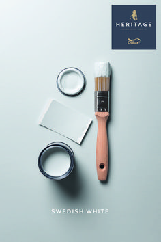 a paintbrush and some other items on a white surface with heritage logo above it