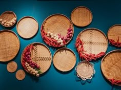 several baskets are arranged on a blue surface with beads and tassels in them