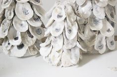 two ceramic trees made out of seashells sitting on a table next to each other