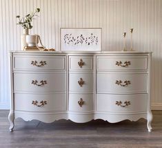 a white dresser with gold handles and drawers