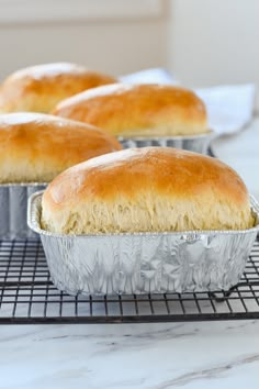 four loafs of bread sitting on top of a cooling rack