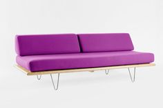 a purple couch sitting on top of a wooden table