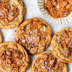 chocolate chip cookies with powdered sugar and chopped walnuts in the middle on a white paper plate