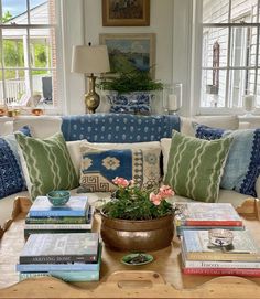 a living room filled with lots of furniture and books on top of a coffee table