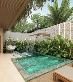 an outdoor swimming pool with waterfall surrounded by plants and greenery, next to a lounge chair