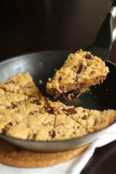 chocolate chip cookie bars in a skillet with a spatula scooping them out