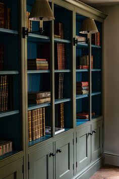 a bookcase with many books and lamps on it's sides in a room