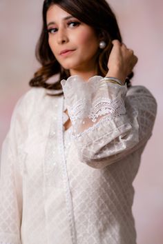 Off-white kurta with moroccan woven motifs and pearl embroidered hem. Paired with cotton pant and dupatta.
Components:3
Pattern:Woven, Embroidery
Type of Work:Moroccan, pearl
Neckline:Scallop V neck
Sleeve Type:Long sleeves
Fabric:Kurta: Woven Chanderi, Pant: Cotton, Dupatta: Organza
Color:Off White
Other Details:
Sheer panelled hem
Lace border
Sheer dupatta
Scallop border sleeve hem
Embroidered neckline
Note: Purse and outfit worn by the other model is not for sale
Occasion:Puja - Aza Fashions Elegant Blouse With Intricate Embroidery For Eid, Elegant Eid Blouse With Intricate Embroidery, Feminine Festive Wedding Blouse, Elegant Festive Chikankari Embroidery Blouse, Elegant White Blouse Piece With Intricate Embroidery, Classic White Sets For Eid, Elegant Unstitched Blouse For Eid, Elegant Blouse With Chikankari Embroidery, White Long Sleeve Blouse With Chikankari Embroidery