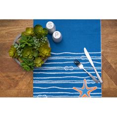 a blue place mat with starfish design on it and utensils next to it