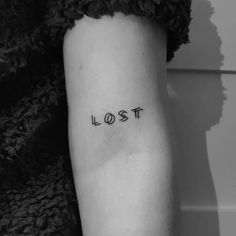 a woman's arm with the word lost tattooed on her left inner arm and lower arm