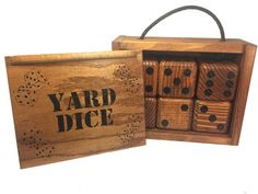 a wooden box with four dices in it and the word yard dice written on them