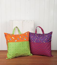 three different colored bags sitting on top of a wooden floor next to each other,