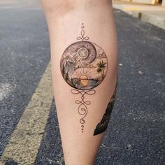 a woman's leg with a tattoo on it that has an image of the moon and mountains