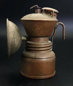 an old fashioned coffee pot with a metal funnel on it's side and the lid open