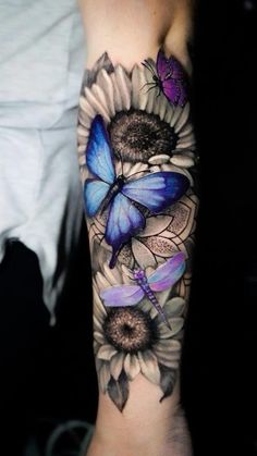 a woman's arm with a blue butterfly and sunflowers tattoo on it