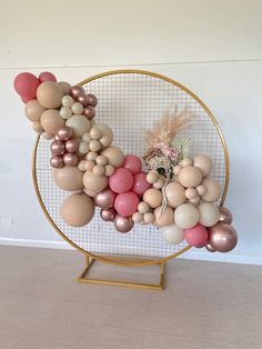 a bunch of balloons are arranged in a circle on a stand with a vase and flowers