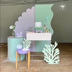 there is a small table with decorations on it in front of a wall and floor