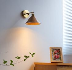 a lamp is on the wall above a dresser