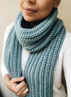 a woman wearing a blue knitted scarf