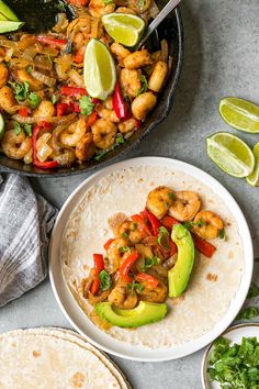 shrimp fajita with avocado and cilantro on the side next to tortillas