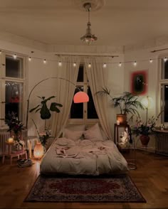 a bedroom with lots of plants and lights on the ceiling, along with an unmade bed