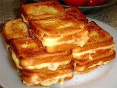 a stack of grilled cheese sandwiches sitting on top of a white plate