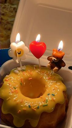 two candles are placed on top of a donut