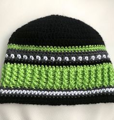 a crocheted black and green beanie hat