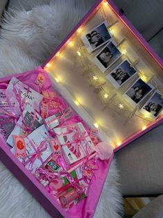 a pink box filled with lots of items on top of a white furnishing