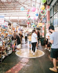 many people are walking through an open market