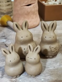 four ceramic rabbits sitting on top of a wooden table