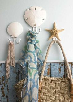 a purse and two starfish hooks hang on the wall next to a wicker basket