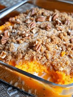 a casserole dish with pecans on top and crumbs in it