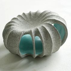 a gray and blue vase sitting on top of a white table