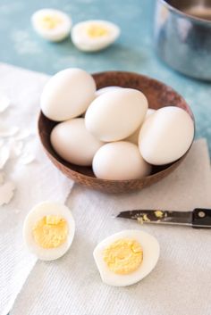 several eggs in a bowl next to a knife