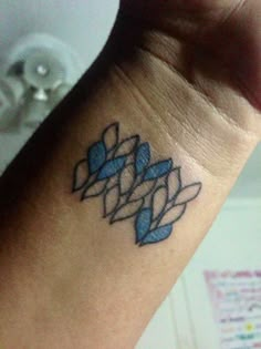 a tattoo on the wrist of a person with a blue ribbon around it's wrist