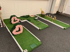 the golf course is made out of artificial grass and flowers on it, with pink roses in the shape of numbers