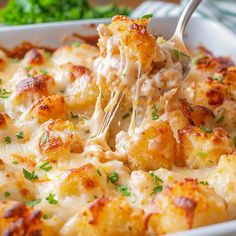 a close up of a casserole in a white dish with a fork sticking out of it