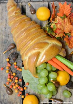 a loaf of bread surrounded by fruits and vegetables