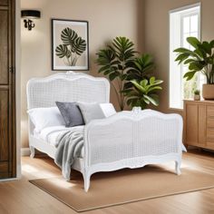 a white bed sitting on top of a hard wood floor next to a wooden dresser