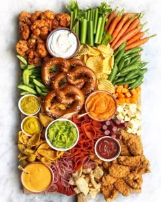 a large platter filled with different types of food and dipping sauces on top of it