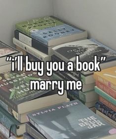 a pile of books sitting next to each other on top of a wooden table with the words i'll buy you a book marry me