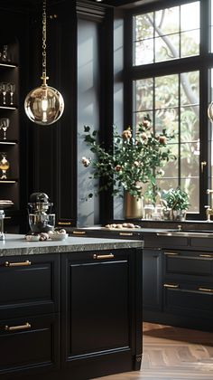 a kitchen with black cabinets and marble counter tops is pictured in this image, there are two hanging lights above the island