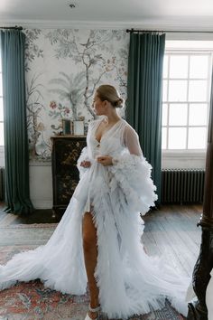 a woman in a white dress is standing on the floor with her legs spread out