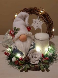 a christmas decoration with a candle and a santa clause figurine in the center