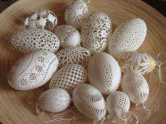 some white eggs are sitting on a wooden plate with string attached to the top one