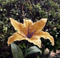 a large yellow flower sitting on top of a lush green forest filled with trees and bushes