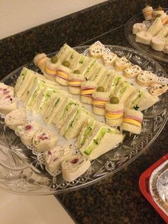 several sandwiches are arranged on a platter and ready to be cut into small pieces